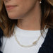 Close-up of a person wearing a pearl necklace and earrings.